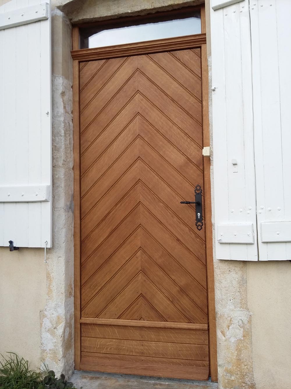 Porte d’entrée en bois avec lames disposées en chevrons
